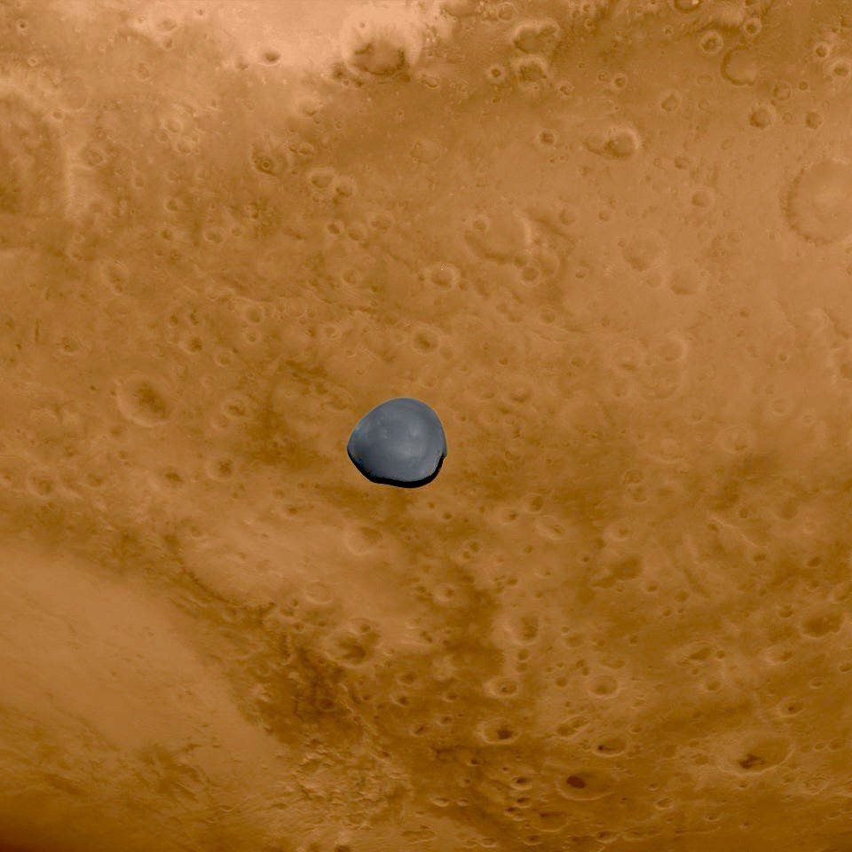 Deimos fotografiado por la cámara AFC de Hera durante el sobrevuelo del 12 de marzo de 2025, con la superficie de Marte al fondo.