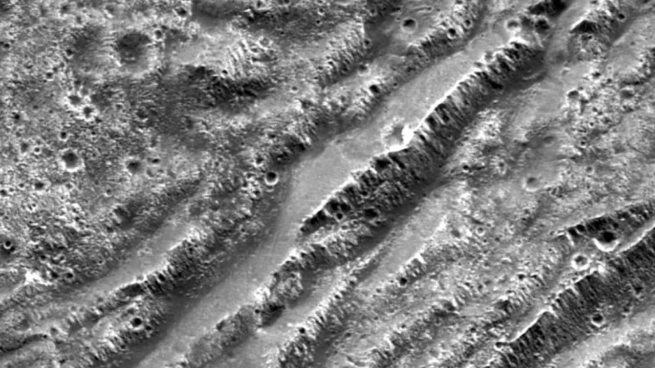 Escarpes en forma de escalones en el terreno oscuro de Nicholson Regio en Ganímedes