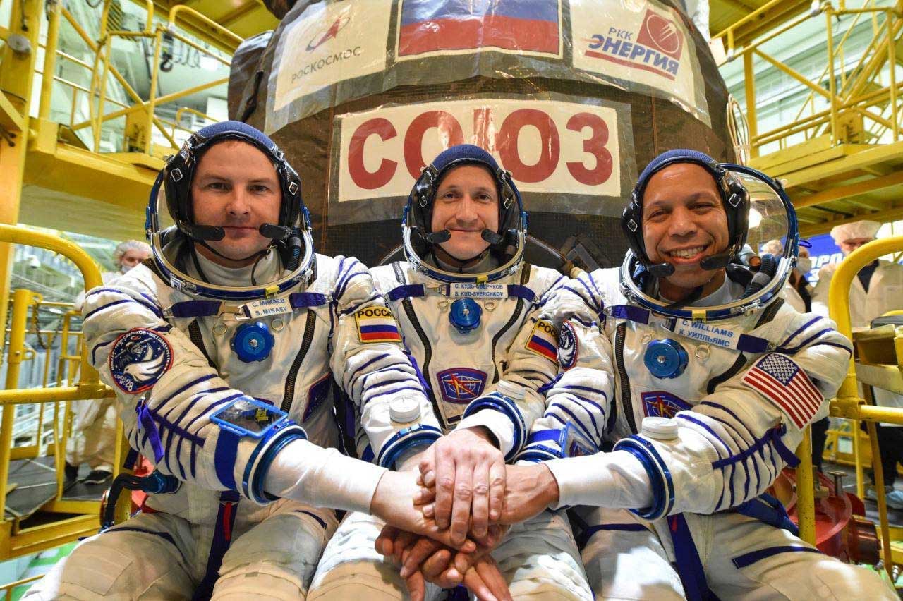 La tripulación de Soyuz MS-28 posa con los trajes Sokol dentro del edificio de preparación en Baikonur