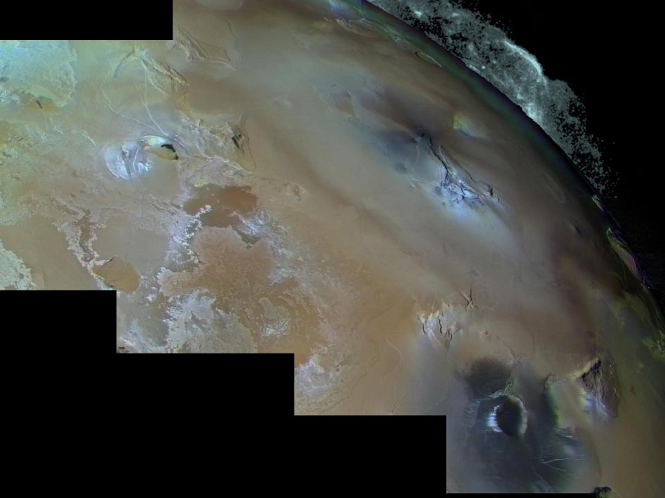 Imagen en color mejorado de la región volcánica de Pele en Ío, donde una pluma en forma de paraguas se eleva unos 300 kilómetros sobre la superficie. El respiradero aparece como una mancha oscura al norte de la meseta triangular situada a la derecha del centro del mosaico. Los depósitos de la pluma cubren un área comparable al tamaño del estado de Alaska, formando un extenso manto rojizo. A la izquierda se observan flujos volcánicos de colores intensos, ricos en compuestos de azufre.