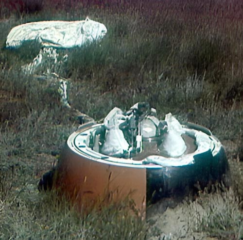 Cápsula de descenso de una sonda del programa Venera tras una prueba en tierra, con el paracaídas parcialmente desplegado y el módulo presurizado expuesto, utilizada para ensayos de recuperación y validación estructural.