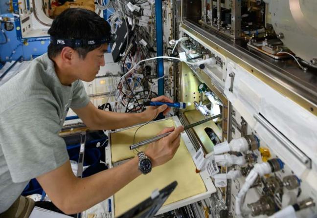 El astronauta Takuya Onishi inspecciona equipamiento científico en el módulo Kibo de la ISS